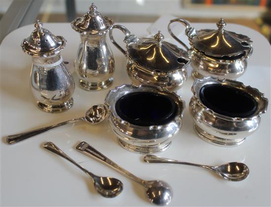 Silver four-piece condiment set, fitted blue glass liners, silver salt & pepper & a sugar spoon